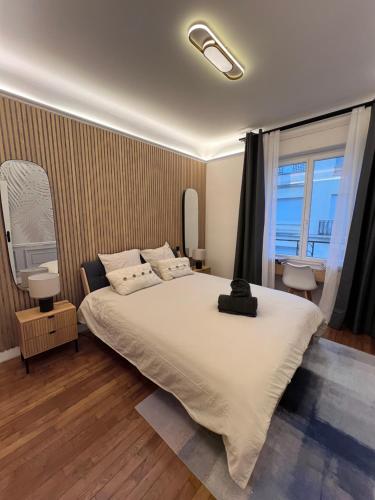 une chambre avec un grand lit blanc et une fenêtre dans l'établissement Appartement familial 6 couchages, à Nancy