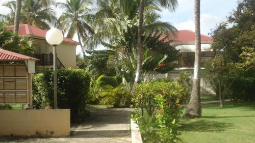 une maison avec des palmiers devant une cour dans l'établissement Pa ni problème, à Saint-François