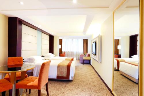 ein Hotelzimmer mit 2 Betten und einem Tisch in der Unterkunft Casa Real Hotel in Macau