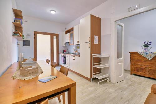 a kitchen with white cabinets and a wooden table at la Casa del Vino - La Botte in Tollo