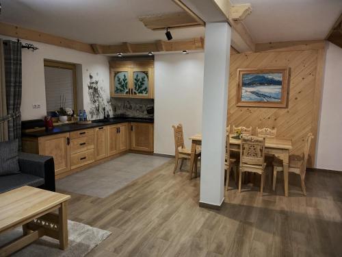 - une cuisine et une salle à manger avec une table et des chaises dans l'établissement Kozie Turnie, à Poronin