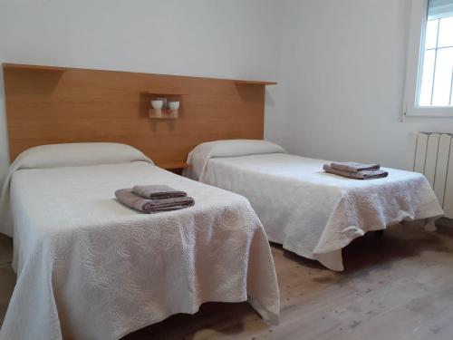 two beds in a room with towels on them at Apartamentos Santillán in San Vicente de la Barquera