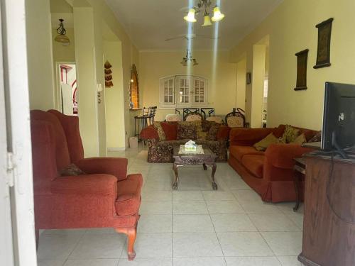 a living room with two couches and a tv at Hasna chalet in El Alamein