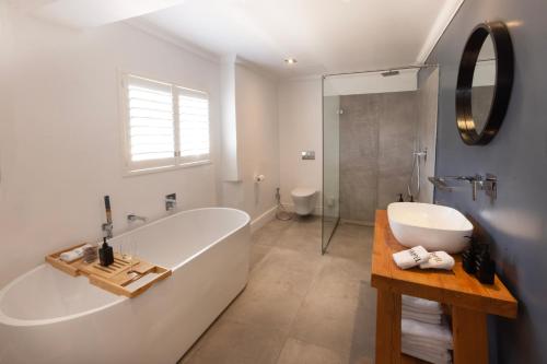 a bathroom with a tub and a shower and a sink at Tempel Wines in Paarl