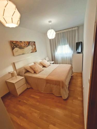 a bedroom with a bed in a room with wooden floors at Piso ESPAZ in Isla de Arosa