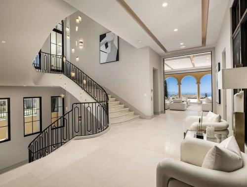 a large living room with a staircase and a living room with chairs at Brown Villa in Edmonton
