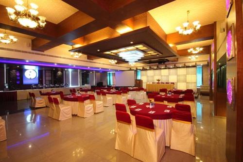 un salón de banquetes con mesas y sillas rojas y blancas en Vihang's Inn, en Thane