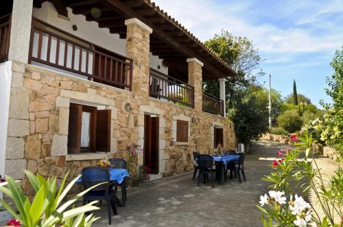 una casa con mesas y sillas frente a ella en Bandi, en San Teodoro