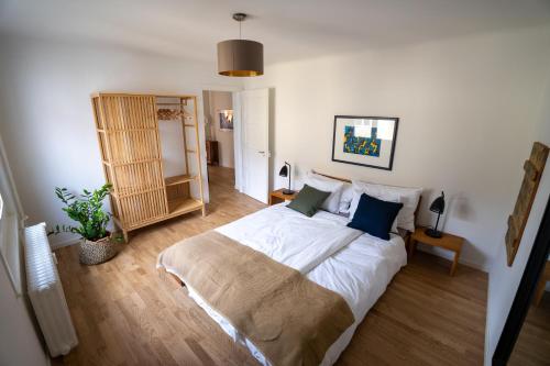 1 dormitorio con 1 cama grande con sábanas blancas y almohadas azules en Jungstay Apartments- near Basel en Basilea