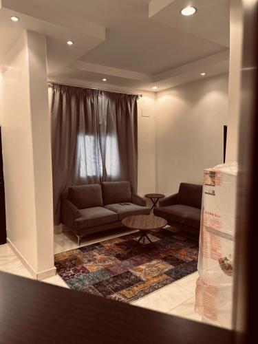 sala de estar con sofá y mesa en اجنحة فندقية 3 Suites en Abalah