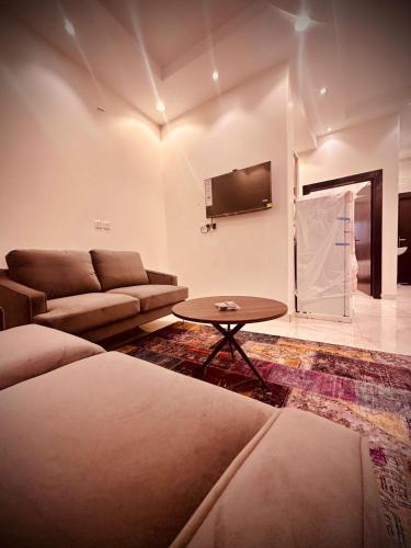 sala de estar con sofá y mesa en اجنحة فندقية 3 Suites en Abalah
