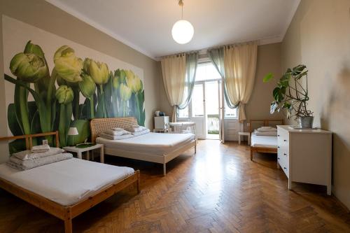 Zimmer mit 2 Betten und Wandgemälde in der Unterkunft Trzy Kafki Private Rooms in Krakau
