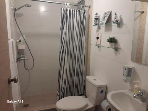 ein Bad mit einer Dusche, einem WC und einem Waschbecken in der Unterkunft Centric and cozy apartment in Punta Cana