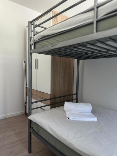 a bedroom with a bunk bed with white sheets at Apartment Štucin in Vipava