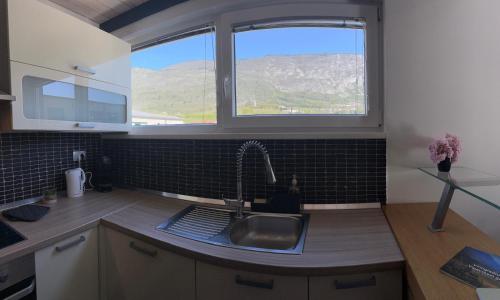Apartment Štucin في فيبافا: مطبخ مع حوض ونافذة كبيرة