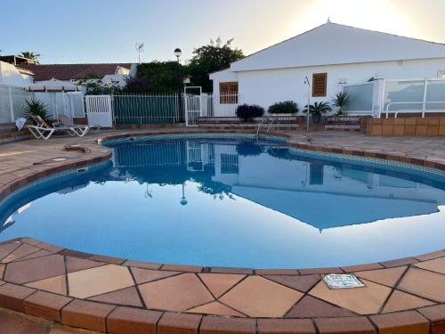 a swimming pool with blue water in a yard at Villa Cecilia, Maspalomas (Nuevo a estrenar) in Maspalomas