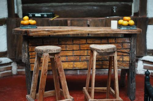 une table en bois avec des oranges et deux tabourets dans l'établissement Bosque de Oro, à Apía
