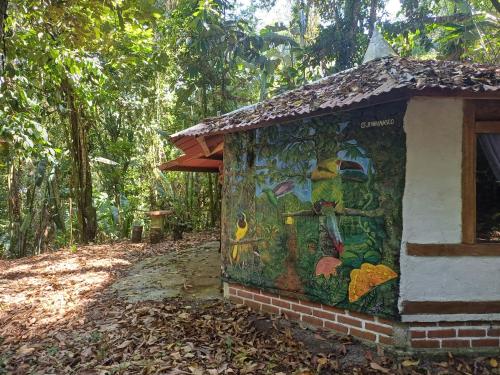 a painting on the side of a building in the woods at Bosque de Oro in Apía