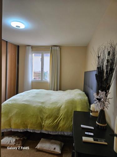 a bedroom with a large bed and a table at Maison romantique entre deux fleuves chez l'habitant in Montereau-Fault-Yonne