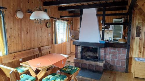 a living room with a table and a fireplace at Domek wypoczynkowy Gowidlino in Gowidlino