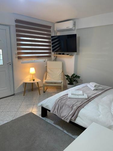 sypialnia z łóżkiem, krzesłem i stołem w obiekcie Little apartment w mieście Patras