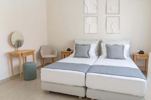 a bedroom with a large white bed with two pillows at Ki.Kos - Private House in Kos