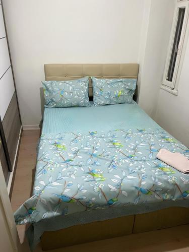 een bed met een blauw dekbed en kussens bij Big and full apartment in Şişli near Taksim in Istanbul