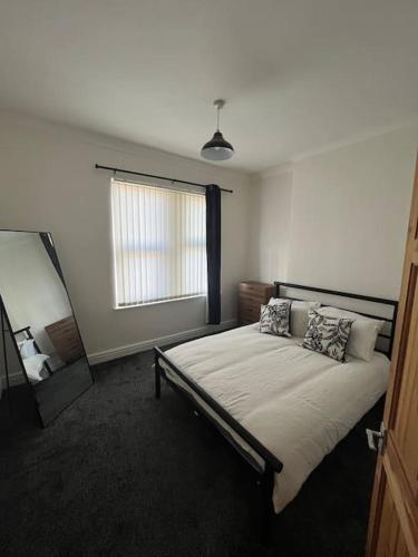 a bedroom with a large bed with a window at Entire house in Liverpool in Litherland