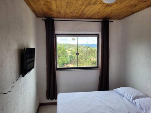 a bedroom with a window with a bed in it at Casa em Lavras Novas in Ouro Preto