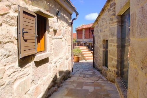 an alley in an old stone building with a window at casa Bicaño in Meis