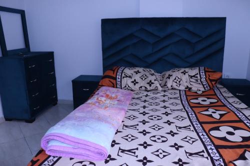 een slaapkamer met een bed met een zwart-wit dekbed bij YOUR HOUSE in Rabat