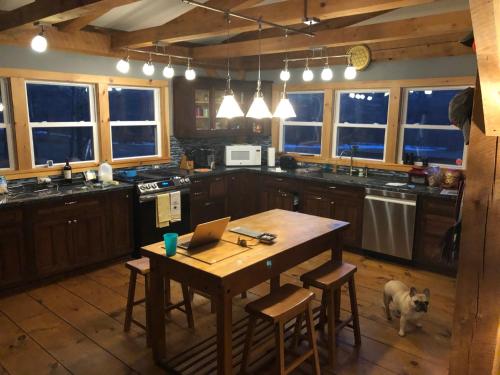 una cucina con un tavolo di legno e un cane dentro di Dancing Barefoot Farms a Pawlet