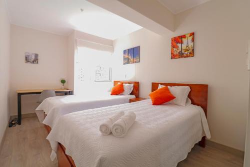 a bedroom with two beds with towels on them at Beautiful floor 9th apartment Pool Gym Barranco in Lima