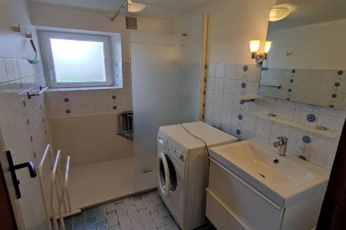 une salle de bain avec une machine à laver et un lavabo dans l'établissement Gîte Ty Maen à Plouhinec 56 4pers, à Plouhinec