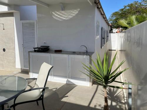 a patio with a glass table and a potted plant at Villa Cecilia, Maspalomas (Nuevo a estrenar) in Maspalomas