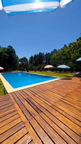 a swimming pool with a wooden deck next to at Quinta Cáceres in Santa Ana