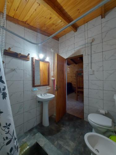 a bathroom with a sink and a toilet and a mirror at Quinta Cáceres in Santa Ana