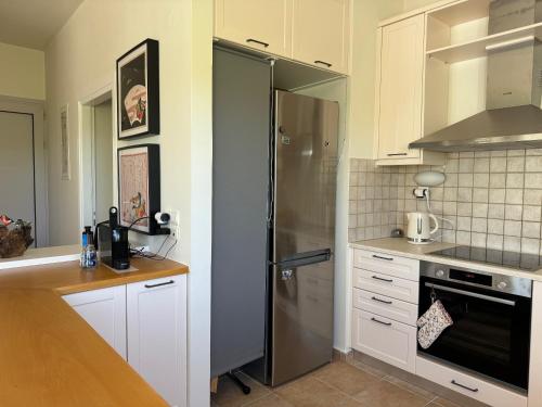 a kitchen with a stainless steel refrigerator and white cabinets at Primavera Retreat in Chania