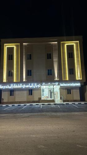 a building with lights on the side of it at night at توبال الماسي in Sīdī Ḩamzah