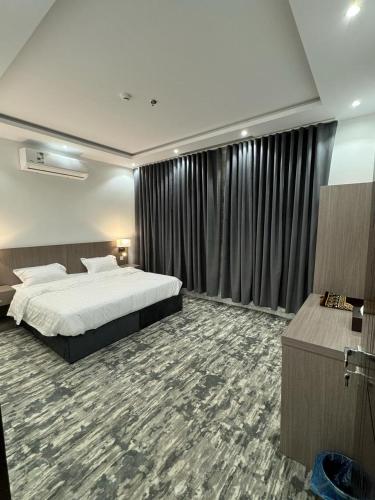 um quarto de hotel com uma cama e uma grande janela em توبال الماسي em Sīdī Ḩamzah