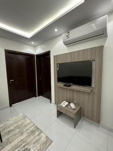 uma sala de estar com uma televisão de ecrã plano na parede em توبال الماسي em Sīdī Ḩamzah