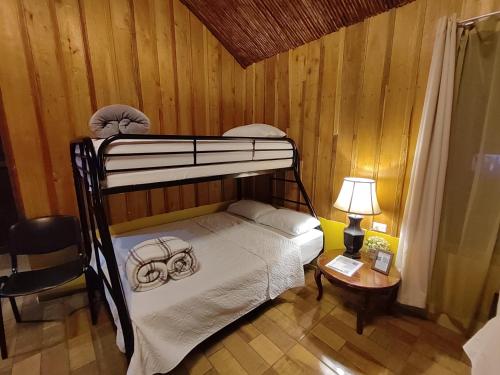 a bedroom with a bunk bed and a table with a lamp at Las Cabañas in Venecia
