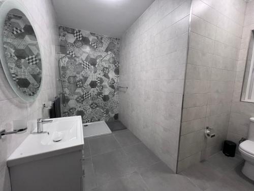 uma casa de banho com um lavatório, um WC e um espelho. em Zenia Court em Marsaskala