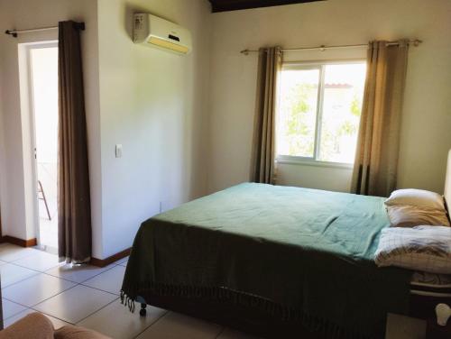 a bedroom with a bed and a window at Residence Cotê d' Azur in Imbassai