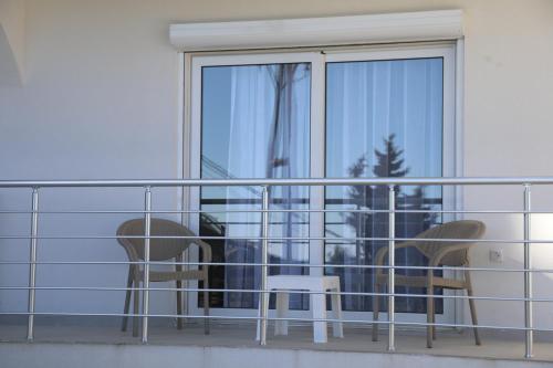 a balcony with two chairs and a window at Villa Palace in Ulcinj