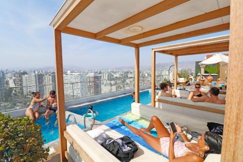 a group of people laying around a swimming pool at Beautiful floor 9th apartment Pool Gym Barranco in Lima