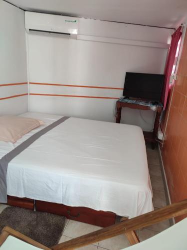 een kleine slaapkamer met een bed en een bureau bij La maison du bonheur in Fort-de-France