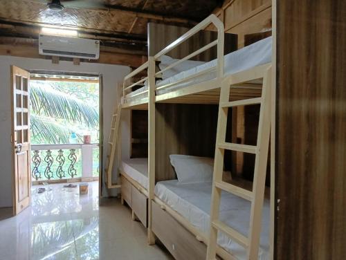 a bunk bed room with two bunk beds and a window at Jeet Hostel & Rooms in Canacona