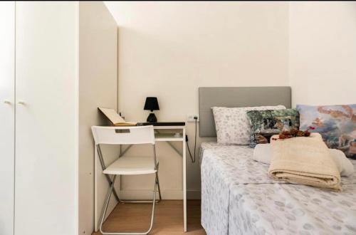 a small bedroom with a bed and a desk at Quiet Love Suites in Barcelona