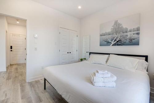 a bedroom with a large white bed with towels on it at M11 Neat & Spacious 1BR in Heart of Plateau MTL in Montréal